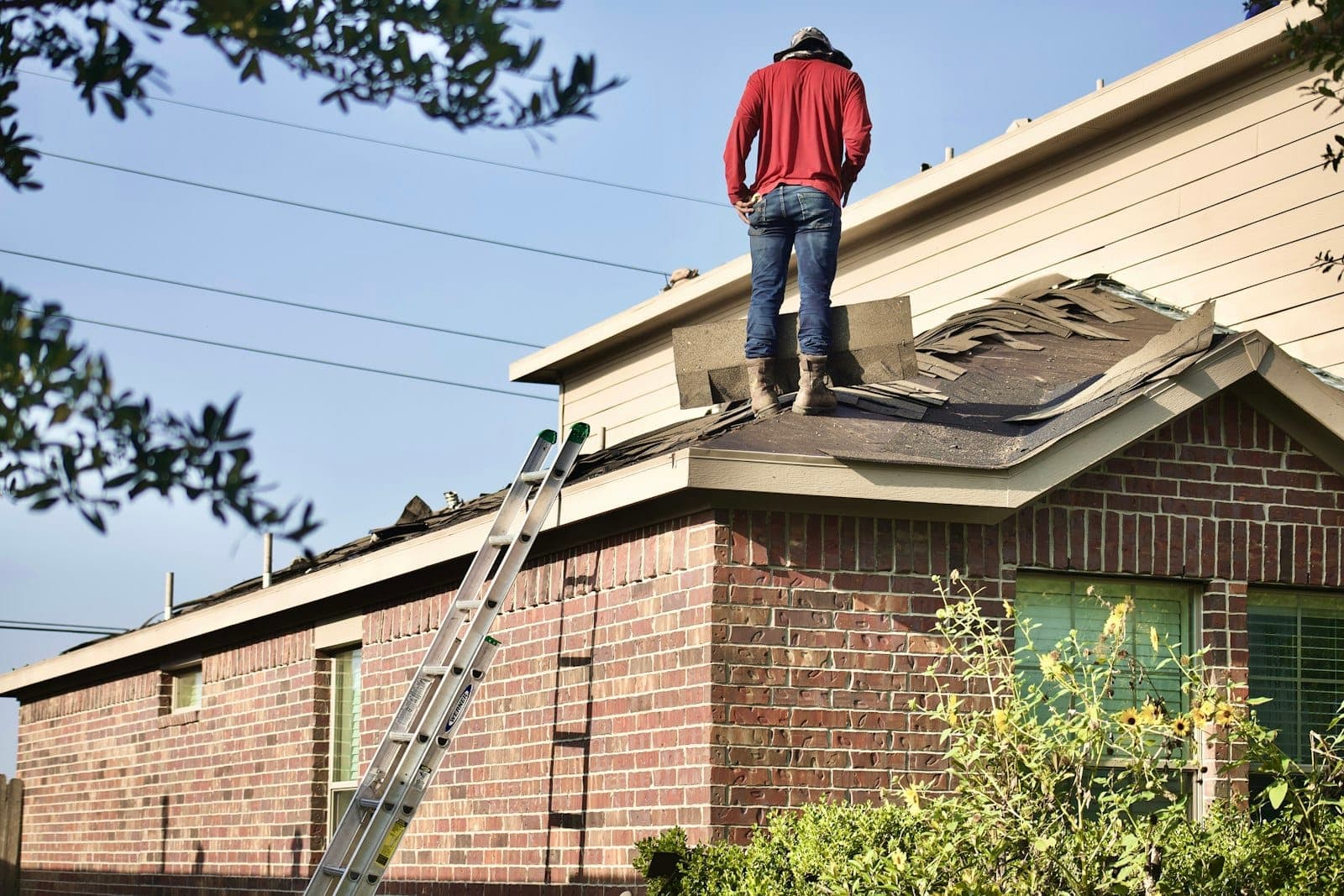 Roof replacement underway on a brick home